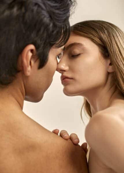 Two people in intimate pose, faces close, tender moment.